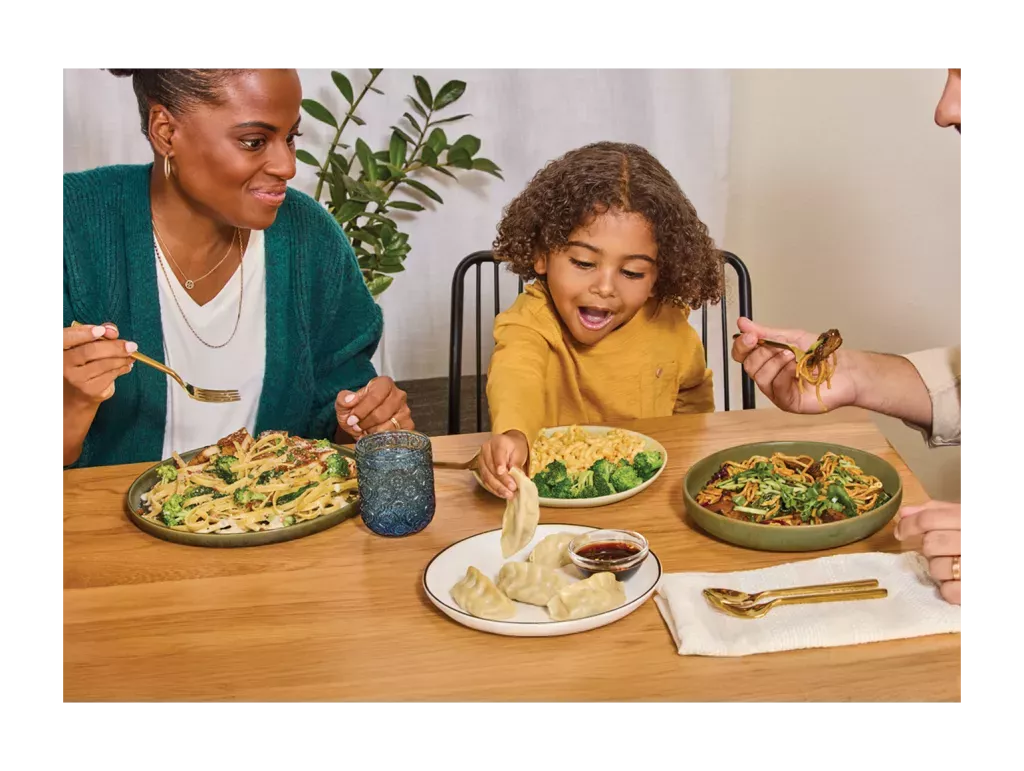 Family enjoying Noodles & Company at a dinner table.