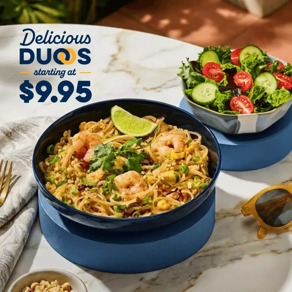 Delicious Duos starting at $9.95. Pad Thai with Shrimp and Side Garden Salad on a marble patio table with a fork, napkin and sunglasses