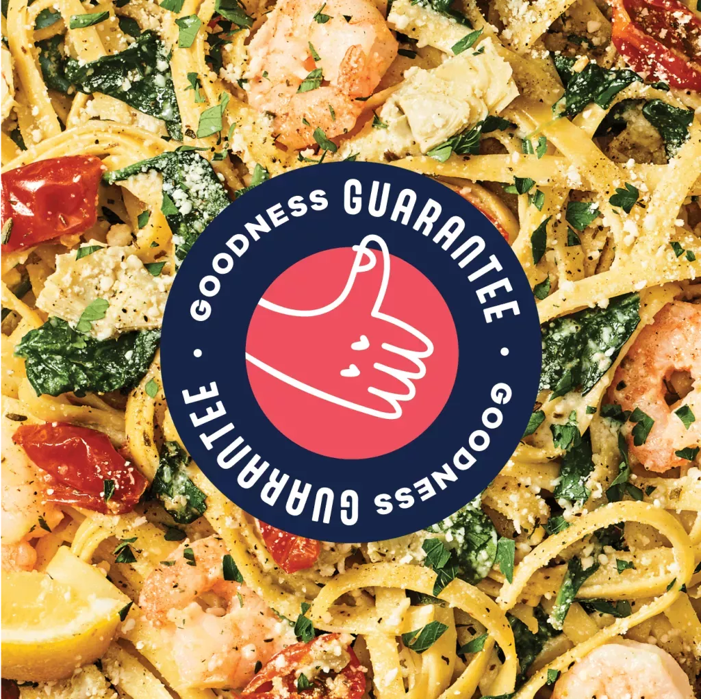 Goodness Guarantee. Logo with thumbs up illustration over zoomed in shot of Lemon Garlic Shrimp Scampi pasta