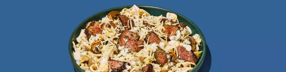 bowl of steak stroganoff on blue background