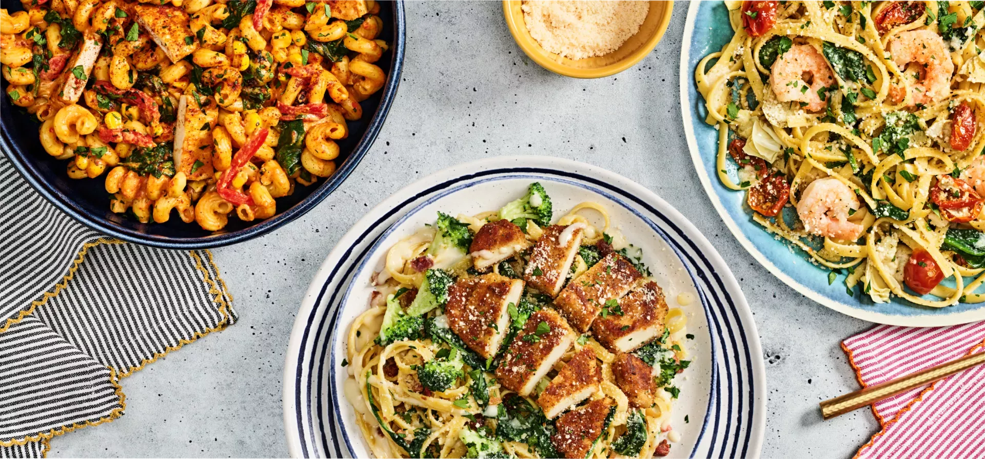 Lemon Garlic Shrimp Scampi, Crispy Chicken Bacon Alfredo, and Chipotle Chicken Cavatappi on decorative plates.